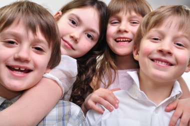 Happy group of children hugging together clipart