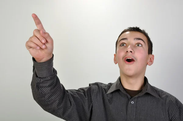 Förvånad teeager pojke pekar uppåt — Stockfoto