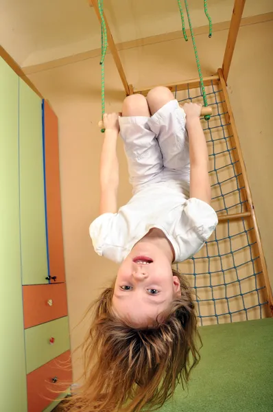 Malá holčička, visí dolů v tělocvičně — Stock fotografie