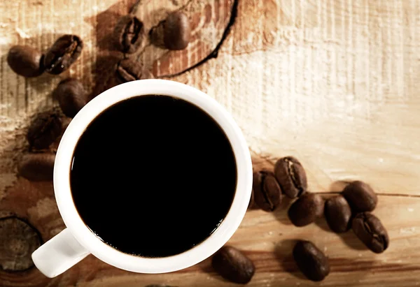 咖啡豆与白木桌上的杯子 — 图库照片
