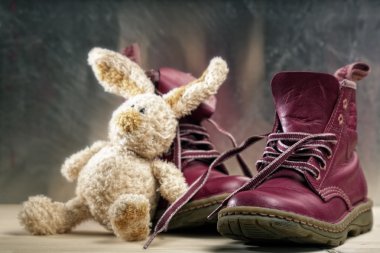 Old shoes and toy close up shot against grunge backgrounds clipart