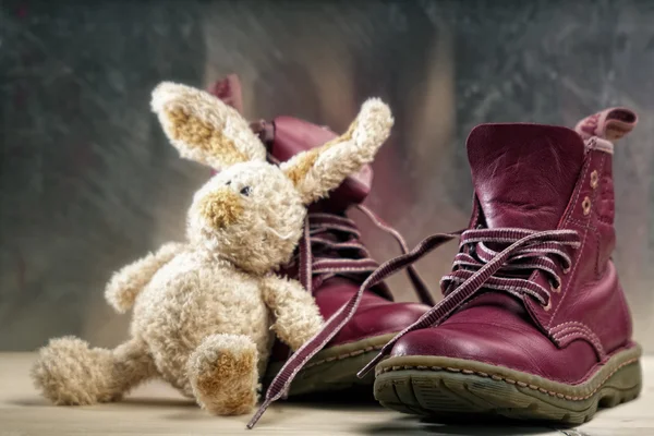Alte Schuhe und Spielzeug in Nahaufnahme vor Grunge-Hintergrund — Stockfoto