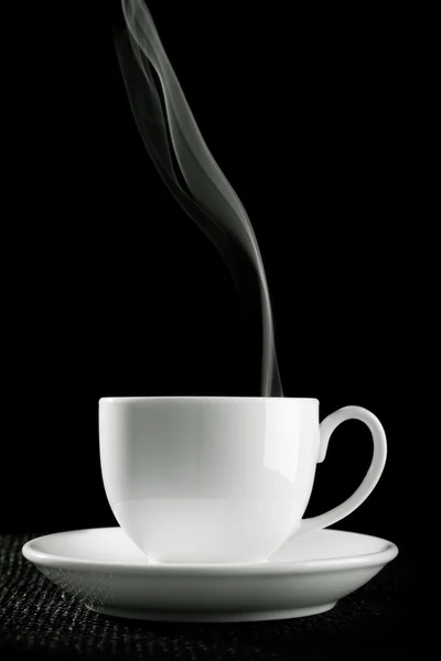 Taza de café sobre la mesa sobre fondo negro —  Fotos de Stock