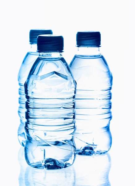 Água mineral de nascente purificada nas garrafas com reflexão — Fotografia de Stock