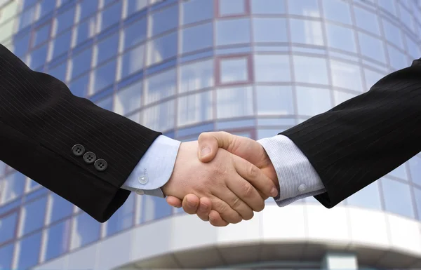Handshake with modern skyscrapers as background — Stock Photo, Image
