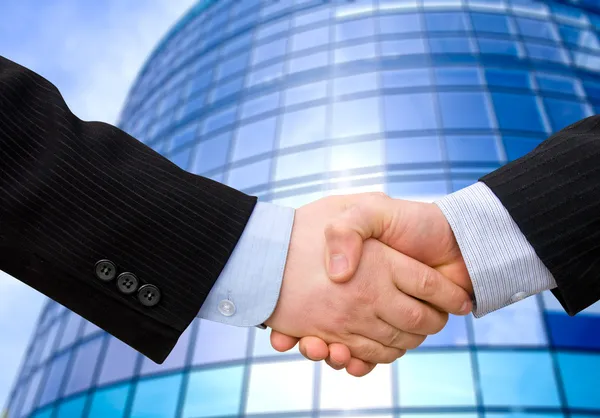 Business accounting balance. Handshake with modern skyscrapers as background. — Stock Photo, Image