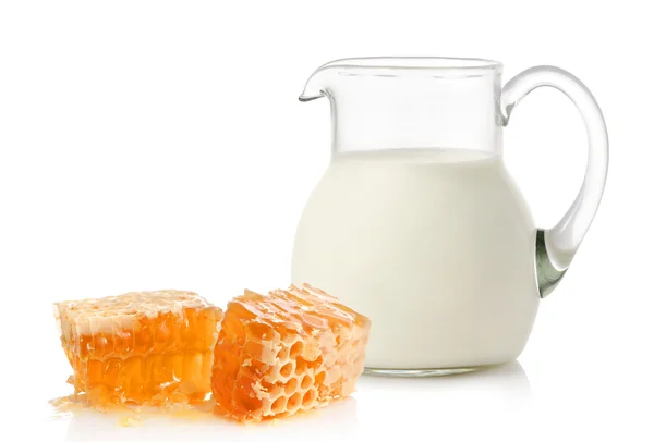 Glass jug with milk and honey — Stock Photo, Image