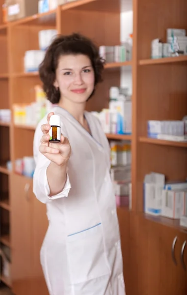 Jovem químico mostrando garrafa de pílulas — Fotografia de Stock