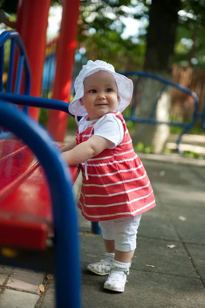 Dziewczynka w pobliżu ławce na placu zabaw — Zdjęcie stockowe