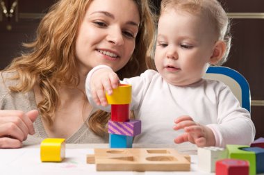 Mother and baby daughter building tower clipart