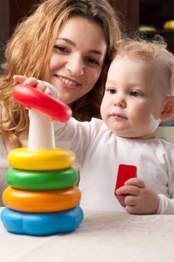 Mother and baby daughter building pyramid clipart