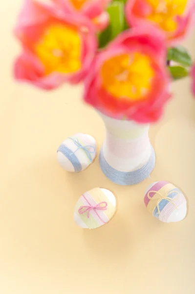 Tulipani rosa, uova di Pasqua e bottiglia avvolta in filo — Foto Stock