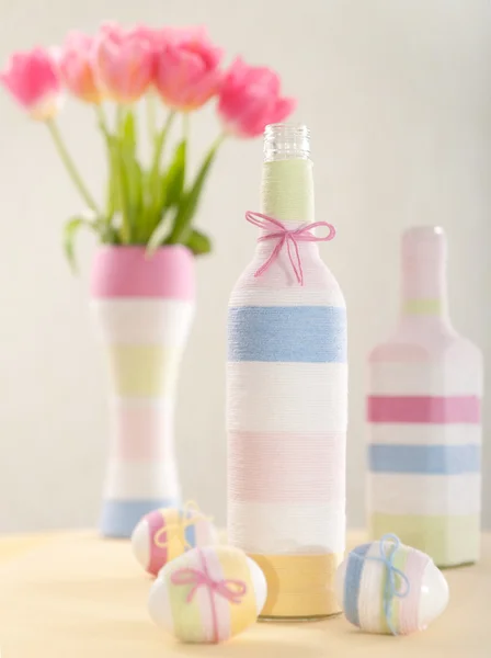 Розовые тюльпаны, пасхальные яйца и бутылка с пряжей — стоковое фото