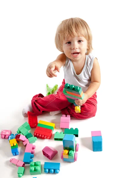 Улыбающийся мальчик, играющий кубиками — стоковое фото