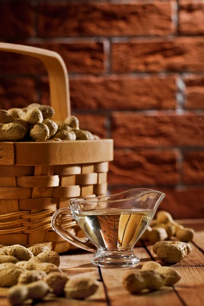 Peanuts in basket and on the table — Stock Photo, Image