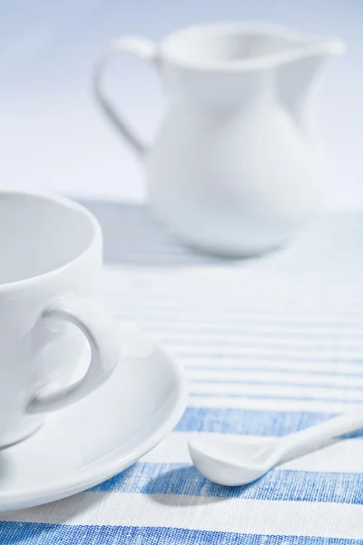 Composition of white cup and spoon and jug — Stock Photo, Image