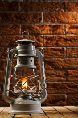 Kerosene lamp on brick background clipart