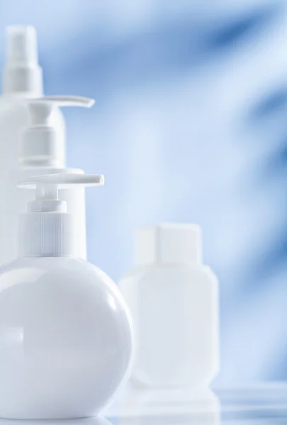 Zusammensetzung von weißen Hautpflegeprodukten auf blauem Hintergrund — Stockfoto