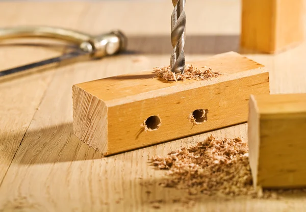 Drilling hole in a wooden plank on table — Stock Photo, Image