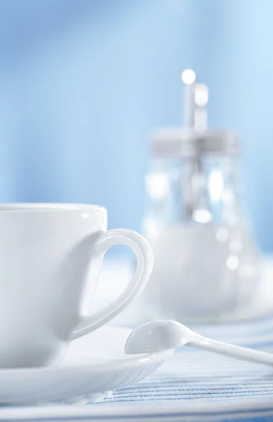 Белая чашка и дозатор сахара — стоковое фото