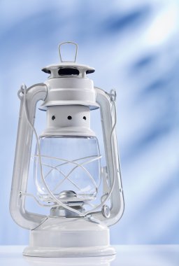 White kerosene lamp on blue background clipart