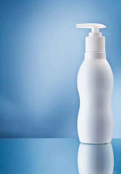 The single white bottle of cream on blue background — Stock Photo, Image