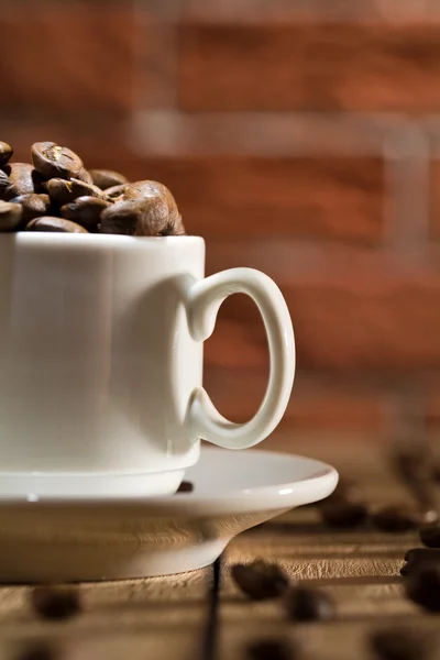 Primer plano taza de café con granos —  Fotos de Stock