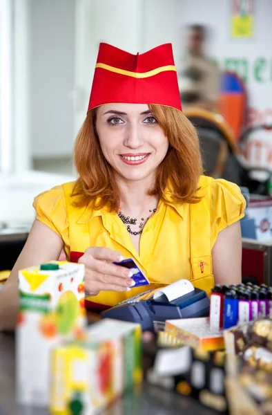 Chica cajera sonriente en uniforme rojo y amarillo — Foto de Stock