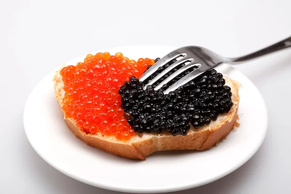 Сэндвич с красной и черной икрой на тарелке — стоковое фото