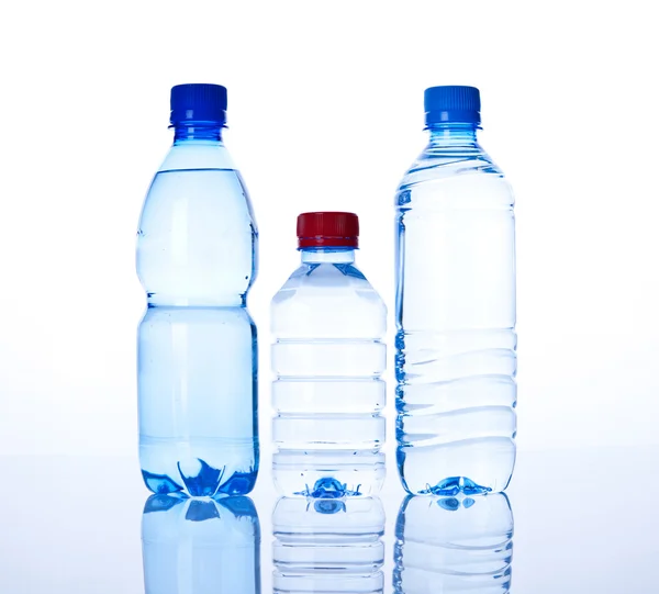 Tři lahvičky vody na bílém pozadí — Stock fotografie