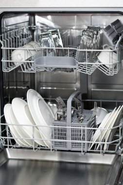 Dishwasher with white plates and steel cutlery clipart