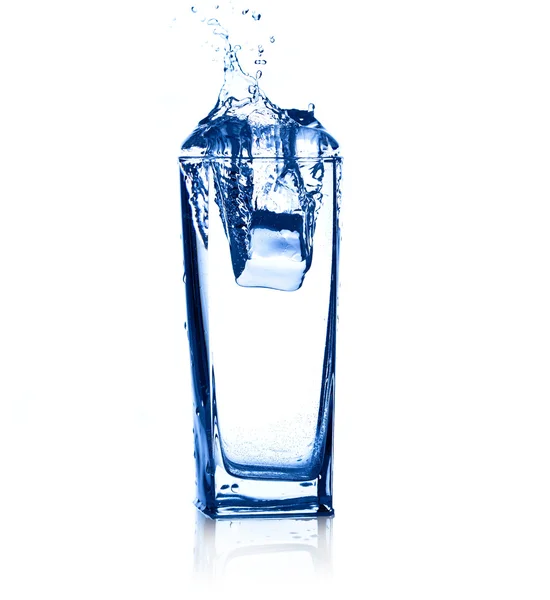 Wasser spritzt aus Eiswürfeln, die in ein Glas fallen. — Stockfoto
