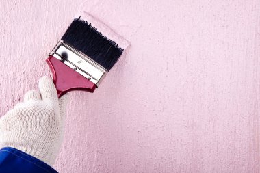Boyacı fırça duvarını pembe renge boyuyor