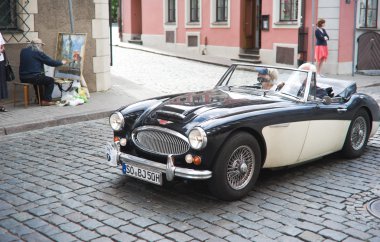 Vintage car in street of old Riga center clipart