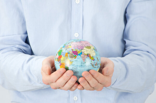 Hands holdings a globe on white