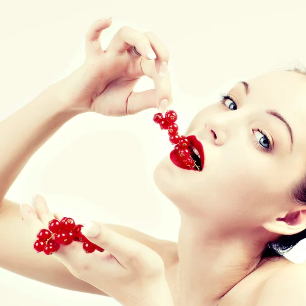 Une femme qui mange séduisamment des baies rouges . — Photo