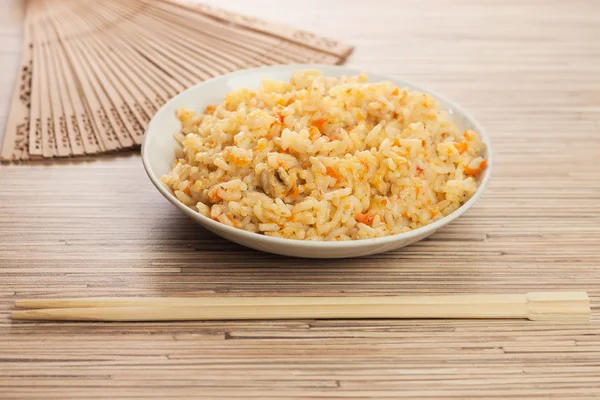 stock image Bowl of rice with chopsticks and fan