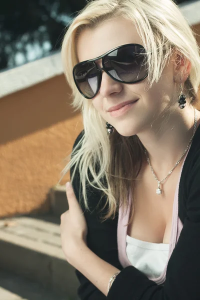 Дівчина в сонцезахисних окулярах сидить на сходах — стокове фото