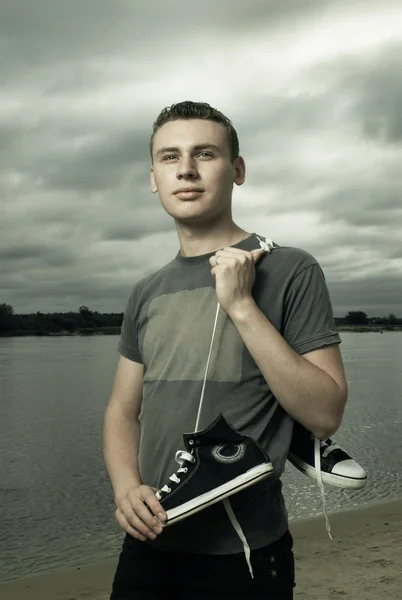 Portrait of young man standing on the river bank — Stock Photo, Image