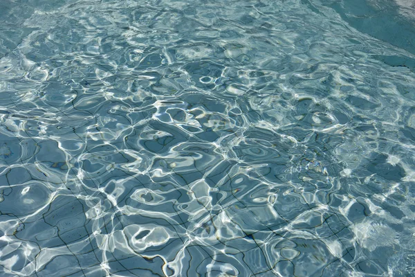 Mooi helder zwembadwater reflecterend in de zon — Stockfoto