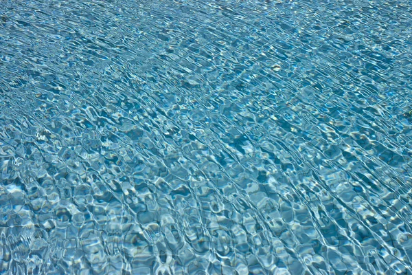 Красивая чистая вода у бассейна, отражающаяся на солнце — стоковое фото
