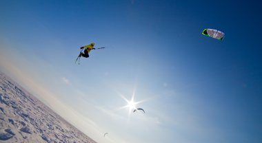 Ski kiting and jumping on a frozen lake clipart