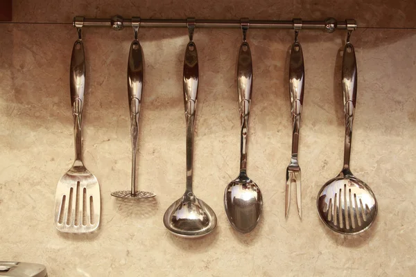 Conjunto de utensílios de cozinha pendurados na parede — Fotografia de Stock