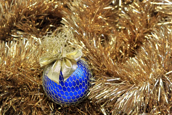 Голубой рождественский бал на золотой мишуре — стоковое фото