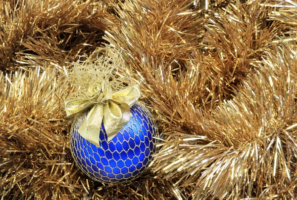Bola de Natal azul em um ouropel dourado — Fotografia de Stock