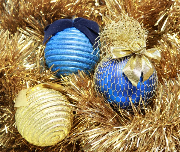 Blå och gyllene julgranskulor på en gyllene glitter — Stockfoto