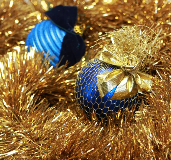 Голубые рождественские шарики на золотой мишуре — стоковое фото