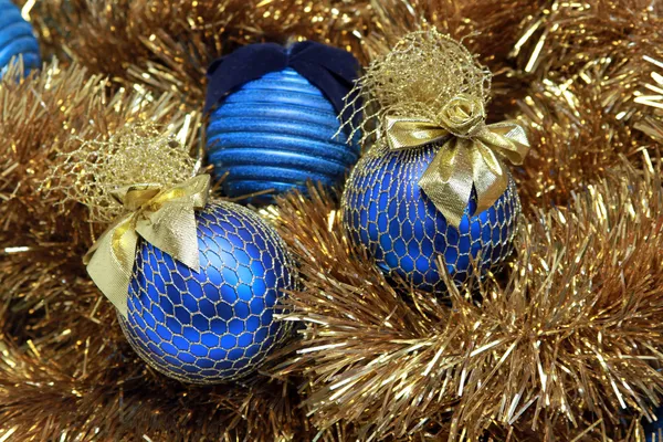 Голубые рождественские шары на золотой мишуре Стоковое Изображение
