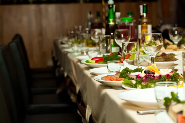 Óculos e pratos na mesa no restaurante - fundo de comida — Fotografia de Stock