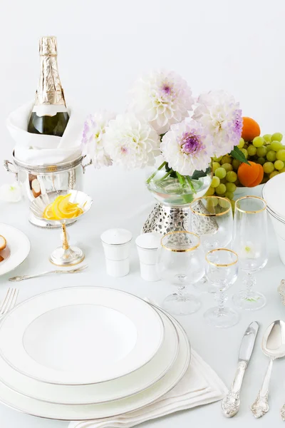 Table with dishes and flowers — Stock Photo, Image